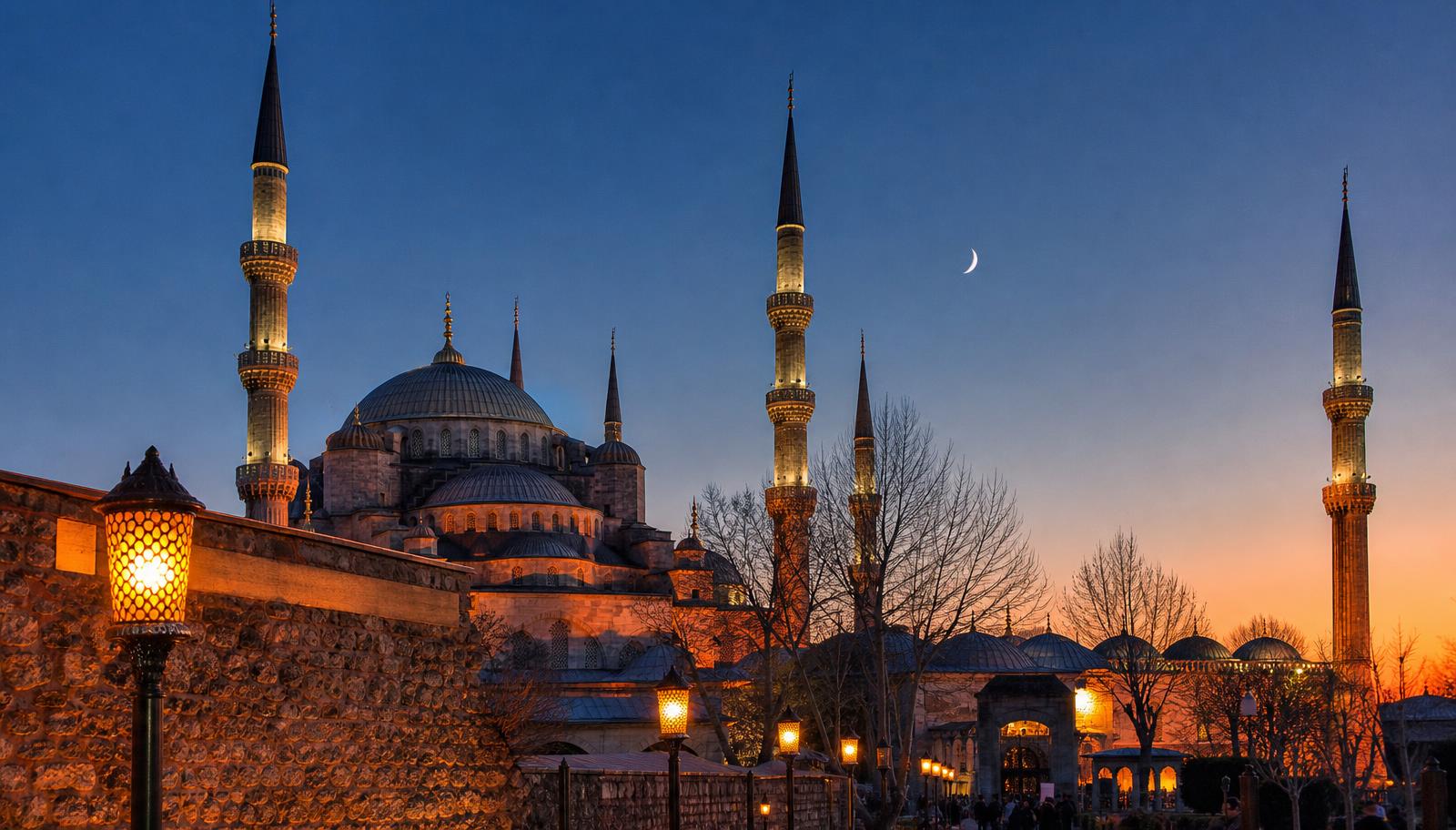 Mosque silhouette with a crescent moon at dusk during Ramadan